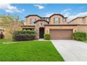 Two-story house with a brown garage door and lush green lawn at 5009 Torchwood Dr, Minneola, FL 34715