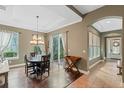 Bright dining room features a wood floor, chandelier, and access to the backyard at 11542 Brightstowe Way, Orlando, FL 32836