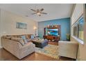 Spacious living room with L-shaped sofa, hardwood floors, and a large TV at 2053 Nobscot Pl, Apopka, FL 32703