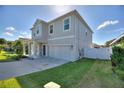 Two-story house with gray siding, two-car garage, and landscaped front yard at 1501 Woodlark Dr, Haines City, FL 33844