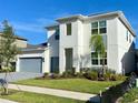 Two-story home with gray garage doors and teal front door at 58 Overleaf Ln, Orlando, FL 32839