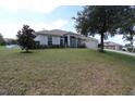 Single-story home on a large lot with mature trees and a landscaped yard at 1545 Blue Sky Blvd, Haines City, FL 33844