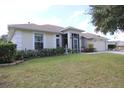 One-story house with a landscaped yard, screened porch, and attached garage at 1545 Blue Sky Blvd, Haines City, FL 33844