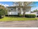 Rear view of a light green townhouse with a well-maintained lawn at 1091 Indigo Dr # 201, Celebration, FL 34747