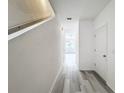 Bright hallway with stairs and light gray vinyl flooring at 947 Grandin St, Davenport, FL 33837
