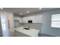 Modern kitchen featuring white cabinets and a large island at 3112 Windswept Way, Wildwood, FL 34785