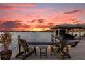 Relaxing dockside view at sunset with chairs and a boat at 6320 S Sylvan Lake Dr, Sanford, FL 32771