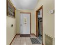 Front entry with tiled floor, white door, and adjacent hallway at 824 Berryhill Cir, Fruitland Park, FL 34731