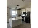 Modern kitchen featuring island, stainless steel appliances, and ample cabinetry at 2521 Oneida Loop, Kissimmee, FL 34747