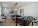 Game room featuring a pool table, foosball table, and a stylish accent wall at 4511 Monado Dr, Kissimmee, FL 34746