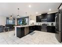 Open concept kitchen with island and dark cabinetry at 8896 Cabot Cliffs Dr, Davenport, FL 33896
