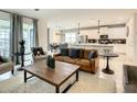 Open concept living space with a brown leather couch and a large wooden coffee table at 1861 Sawyer Palm Pl, Kissimmee, FL 34747