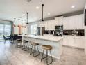 Modern kitchen with white cabinets, quartz countertops, and a breakfast bar at 1861 Sawyer Palm Pl, Kissimmee, FL 34747