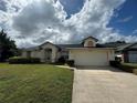 House exterior with a two-car garage and well-manicured lawn at 2606 Eagles Nest Ct, Orlando, FL 32837