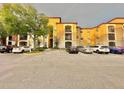 Condo building exterior with parking lot and landscaping at 6153 Metrowest Blvd # 102, Orlando, FL 32835