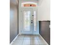 Elegant entryway with a white door, glass inserts, and tile flooring at 3623 Weatherfield Dr, Kissimmee, FL 34746