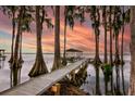 Wooden dock with a gazebo extending over the lake at sunset at 2256 W County Road 44, Eustis, FL 32726