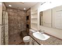 Updated bathroom with walk-in shower, built-in shelving and granite countertop at 7129 Oakwind Dr, Orlando, FL 32818