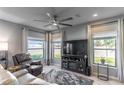 Living room features a large TV, comfortable seating, and plenty of natural light at 356 Smugglers Way, Apopka, FL 32712