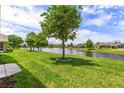 Peaceful backyard with a serene lake view and lush landscaping at 1352 Coconut Palm Cir, Port Orange, FL 32128