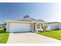 Tan house with a white garage door and green lawn at 231 Begonia Ln, Kissimmee, FL 34759
