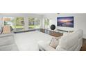 Living room with large TV, comfortable seating, and water views at 8984 Houston Pl # 103, Orlando, FL 32819