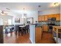 Open kitchen with stainless steel appliances and wood cabinets at 8581 Bay Lilly Loop, Kissimmee, FL 34747