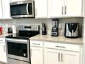 Modern kitchen with stainless steel appliances and white cabinets at 2104 Fleming Mist Pl, Kissimmee, FL 34747