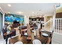 Open dining room area with a dark wood table and a view of the living room and kitchen at 8931 Sydney Ave, Kissimmee, FL 34747
