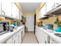 Long galley kitchen with white cabinets and appliances at 1921 Canton St, Orlando, FL 32803