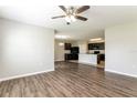 Open concept living room with wood-look floors and a view into the kitchen at 2036 Van Buren Loop, Auburndale, FL 33823