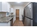 Modern kitchen with white cabinets, granite counters, and stainless steel appliances at 3121 Bon Air Dr, Orlando, FL 32818