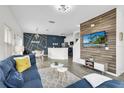 Open living room with stylish decor and a large TV at 4562 Baleno Ln, Kissimmee, FL 34746
