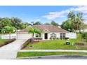One-story house with a landscaped lawn and driveway at 1331 Island Trees Ln, Deland, FL 32720