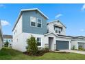 Two-story house with gray and blue siding, stone accents, and a two-car garage at 1352 Silo Dr, St Cloud, FL 34771