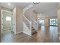 Bright and spacious entryway with tile flooring, staircase, and views to the living area at 1352 Silo Dr, St Cloud, FL 34771