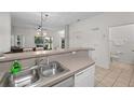 Kitchen with double sink, dishwasher, and view into the living room at 1029 Park Ridge Cir, Kissimmee, FL 34746