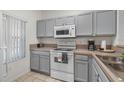 Kitchen with gray cabinets, white appliances, and double sink at 1029 Park Ridge Cir, Kissimmee, FL 34746