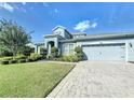 Two-story home with gray siding, paver driveway, and landscaped lawn at 4813 Terra Sole Place, St Cloud, FL 34771