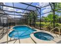 Screened pool and spa with surrounding landscaping at 5295 Wildwood Way, Davenport, FL 33837