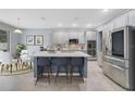 Modern kitchen with an island, stainless steel appliances, and white cabinets at 3149 Jade Tree Pt, Oviedo, FL 32765