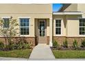 Front door entrance of a townhome with stone accents and landscaping at 164 Holly Village Dr, Davenport, FL 33837