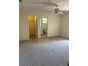 Spacious bedroom with carpeting, ceiling fan, and access to a bathroom and walk-in closet at 2421 Omaha Dr, Deltona, FL 32738