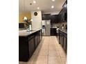 Modern kitchen featuring dark cabinetry, granite countertops, and stainless steel appliances at 9033 Rhodes St, Kissimmee, FL 34747