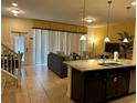 Open floor plan with kitchen island, living area, and dining space at 9033 Rhodes St, Kissimmee, FL 34747