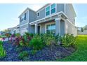 Two-story house exterior with gray siding and lush landscaping at 4009 Winding Meadows St, Apopka, FL 32712