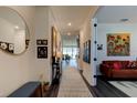 Bright and airy entryway with a large mirror and artwork leading to the living areas at 4009 Winding Meadows St, Apopka, FL 32712
