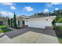 One-story home with a white exterior, blue door, and two-car garage at 1111 Trotwood Blvd, Winter Springs, FL 32708