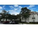 Two-story condo building with gray exterior and tile roofs, ample parking at 14013 Fairway Island Dr # 415, Orlando, FL 32837