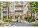 Apartment building entry with landscaping and a planter at 7659 Whisper Way # 102, Reunion, FL 34747